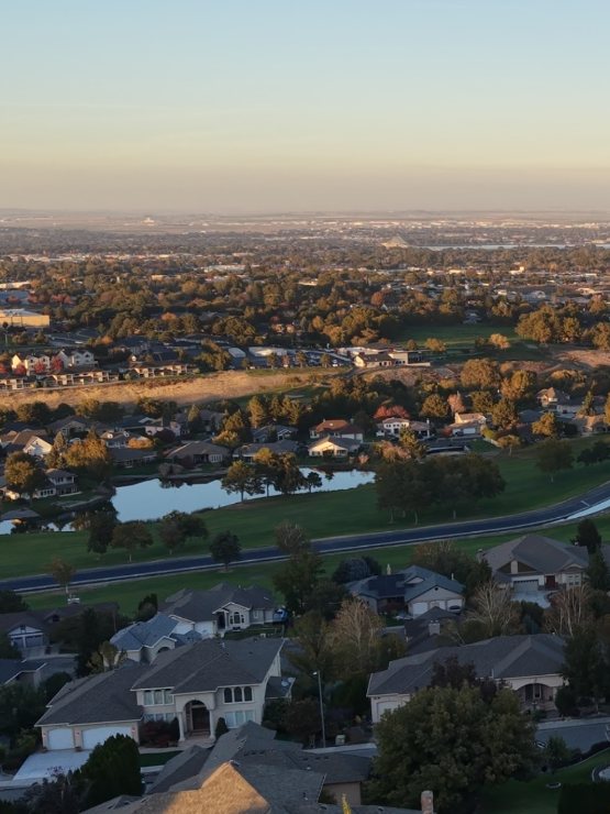 Sunset view over Kennewick neighborhoods and the Canyon Lakes golf course, with the Columbia River in the distance